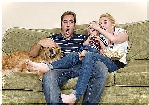 family watching a movie with dog